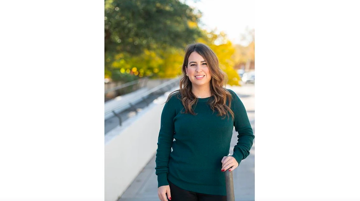 A woman smiles for the camera outside